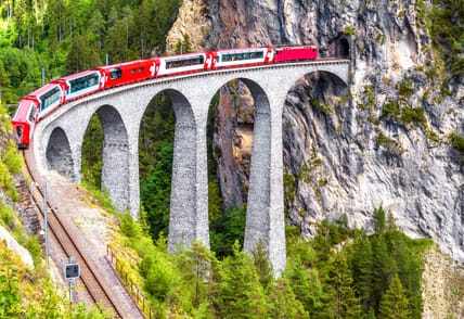 Bernina express on Landwasser Viaduct, Switzerland. It is landmark of Swiss Alps. Nice Alpine landscape in summer. Red glacier train on rail