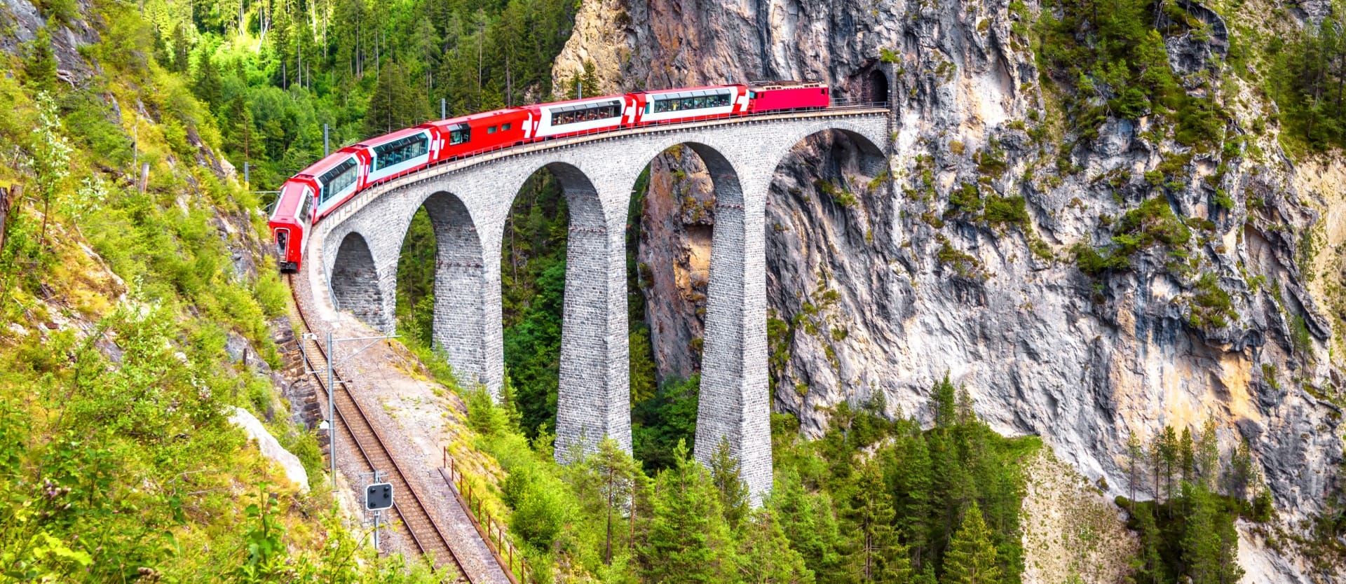 Bernina express on Landwasser Viaduct, Switzerland. It is landmark of Swiss Alps. Nice Alpine landscape in summer. Red glacier train on rail